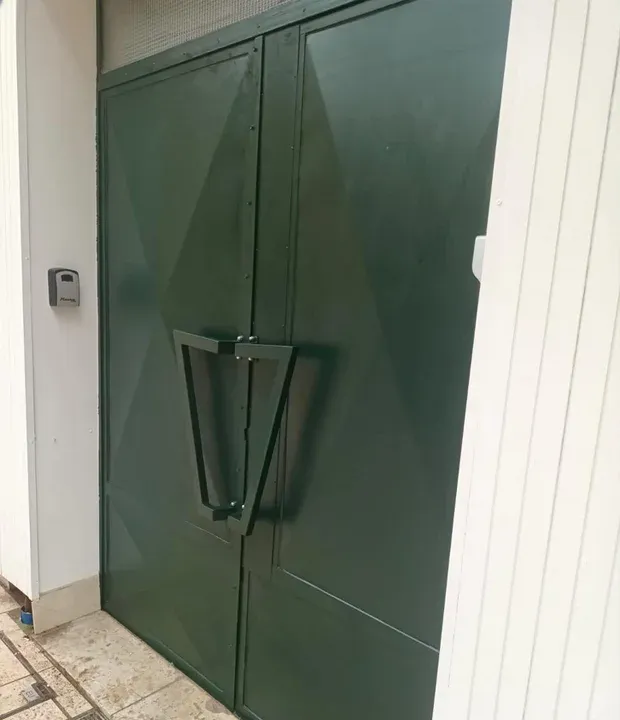 Un portail en métal dans un jardin créé par l'atelier le Chêne et l'Enclume