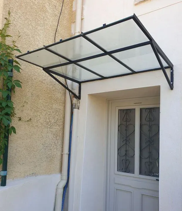 Une marquise devant une porte d'appartement par l'atelier le Chêne et l'Enclume